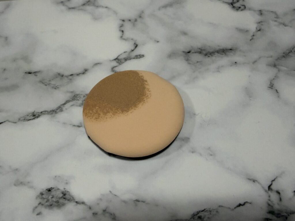 ジョンセンムル クッションファンデ〈フェアライト〉をパフに取った際の色味（ややグレー入りの明るいトーン）が分かる写真